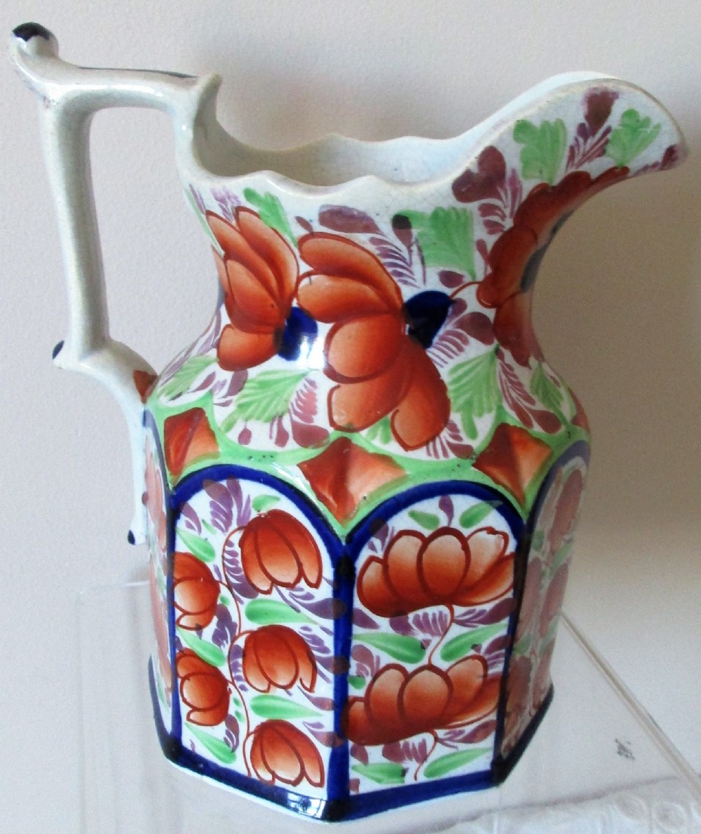 An octagonal Victorian Gaudy Welsh ceramic jug decorated with hand-painted rust-orange flowers, green leaves, and cobalt blue borders. View III