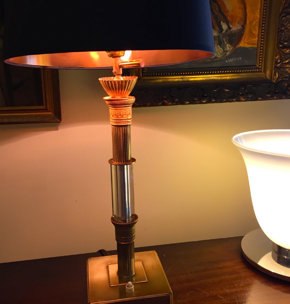 An Empire style desk lamp featuring a reeded brass and crystal column stem set on a square plinth base with a dark shade.