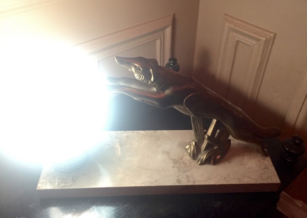 An Art Deco night light featuring a cast bronze leaping greyhound beside a frosted glass globe shade mounted on a rectangular cream marble base. View IV