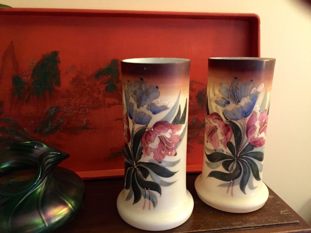 A pair of cylindrical Art Nouveau opaline glass vases with flared bases, decorated with hand-painted blue and pink floral enamel designs and dark gradient rims. View II