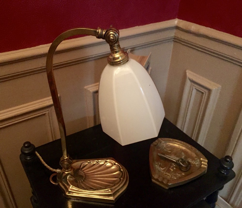 An adjustable Edwardian brass desk lamp with a shell-shaped cast base, curved stem, and a frosted glass shade. View VIII