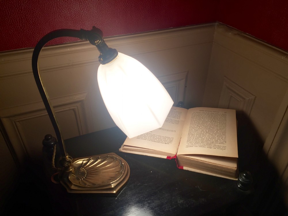 An adjustable Edwardian brass desk lamp with a shell-shaped cast base, curved stem, and a frosted glass shade. View X