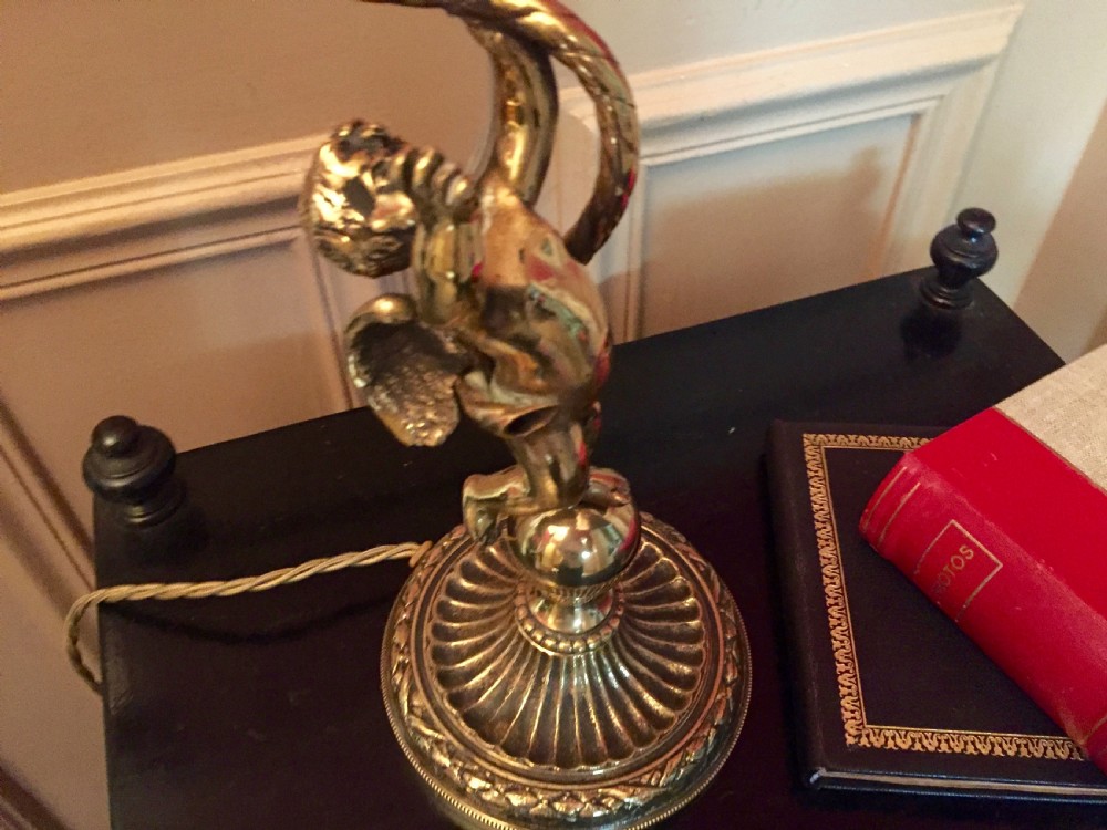 An antique brass and bronze table lamp featuring a cherub figure supporting a twisted gooseneck arm with a ribbed frosted glass shade. View III