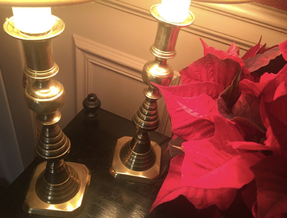 A pair of turned brass table lamps designed in the style of Georgian candlesticks with stepped square bases.