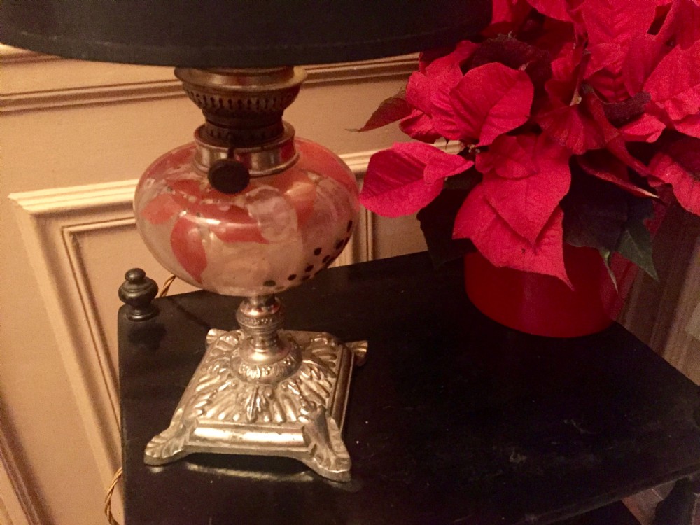 An antique Art Nouveau converted oil lamp featuring a cast metal base, a clear glass font with red enamelled leaf motifs, and a brass gallery. View VIII