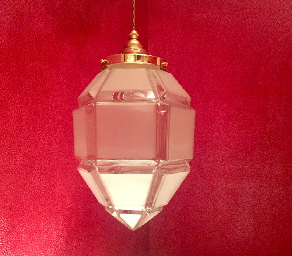 An Art Deco geometric faceted frosted glass pendant light featuring a brass gallery top and pointed lower tip. View VII