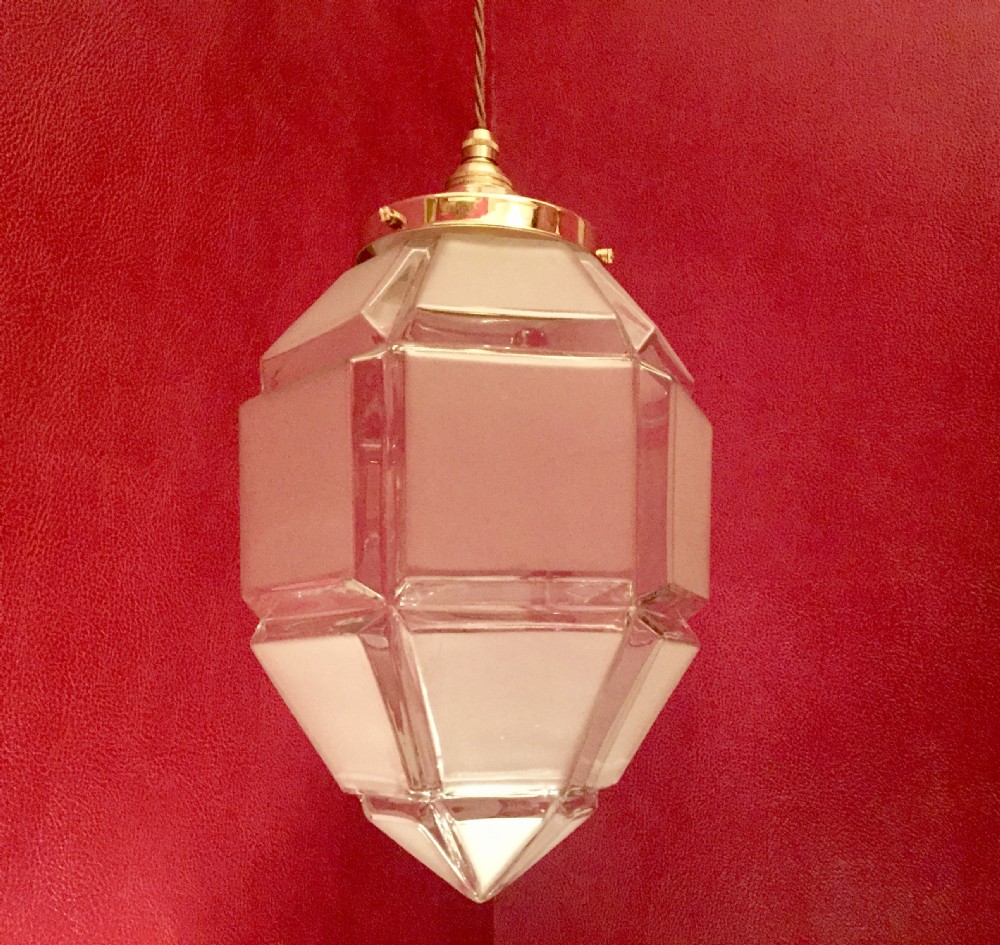 An Art Deco geometric faceted frosted glass pendant light featuring a brass gallery top and pointed lower tip. View III