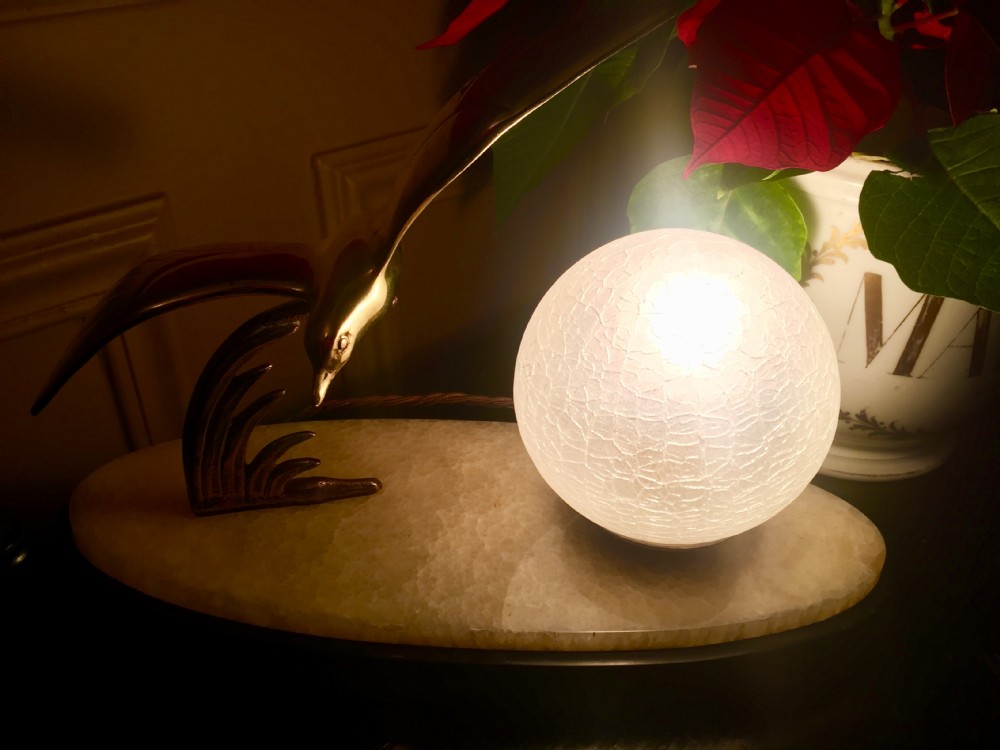 An Art Deco night light featuring a polished brass seagull sculpture and a frosted spherical glass shade mounted on an oval marble base. View VIII