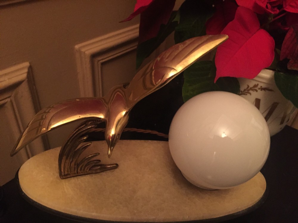An Art Deco night light featuring a polished brass seagull sculpture and a frosted spherical glass shade mounted on an oval marble base. View IX