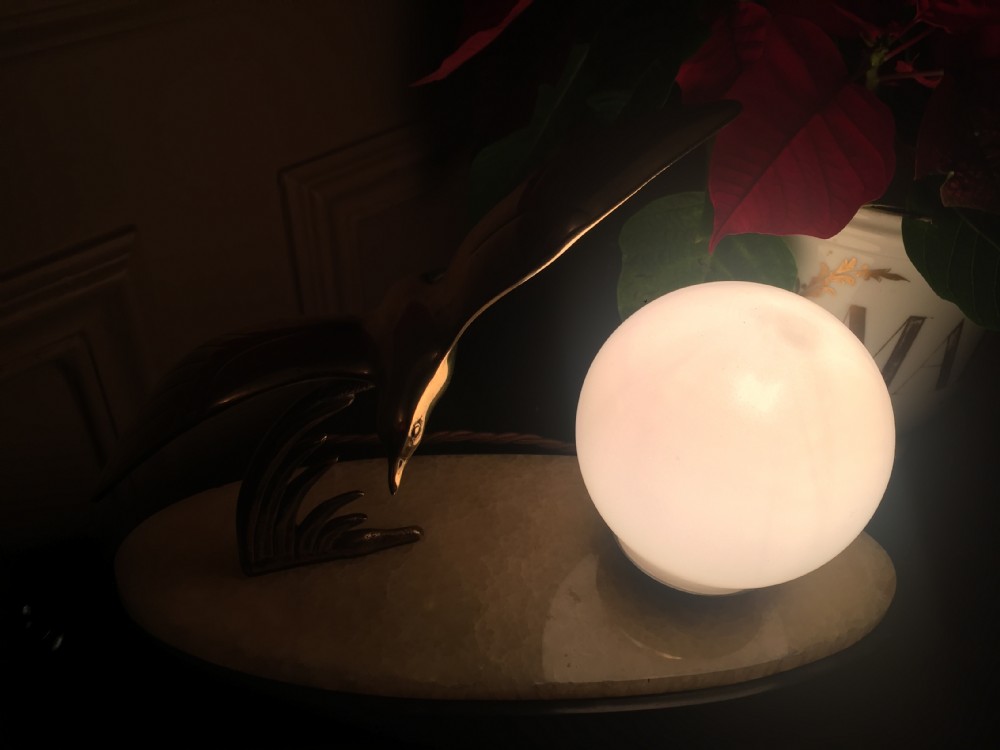 An Art Deco night light featuring a polished brass seagull sculpture and a frosted spherical glass shade mounted on an oval marble base. View X