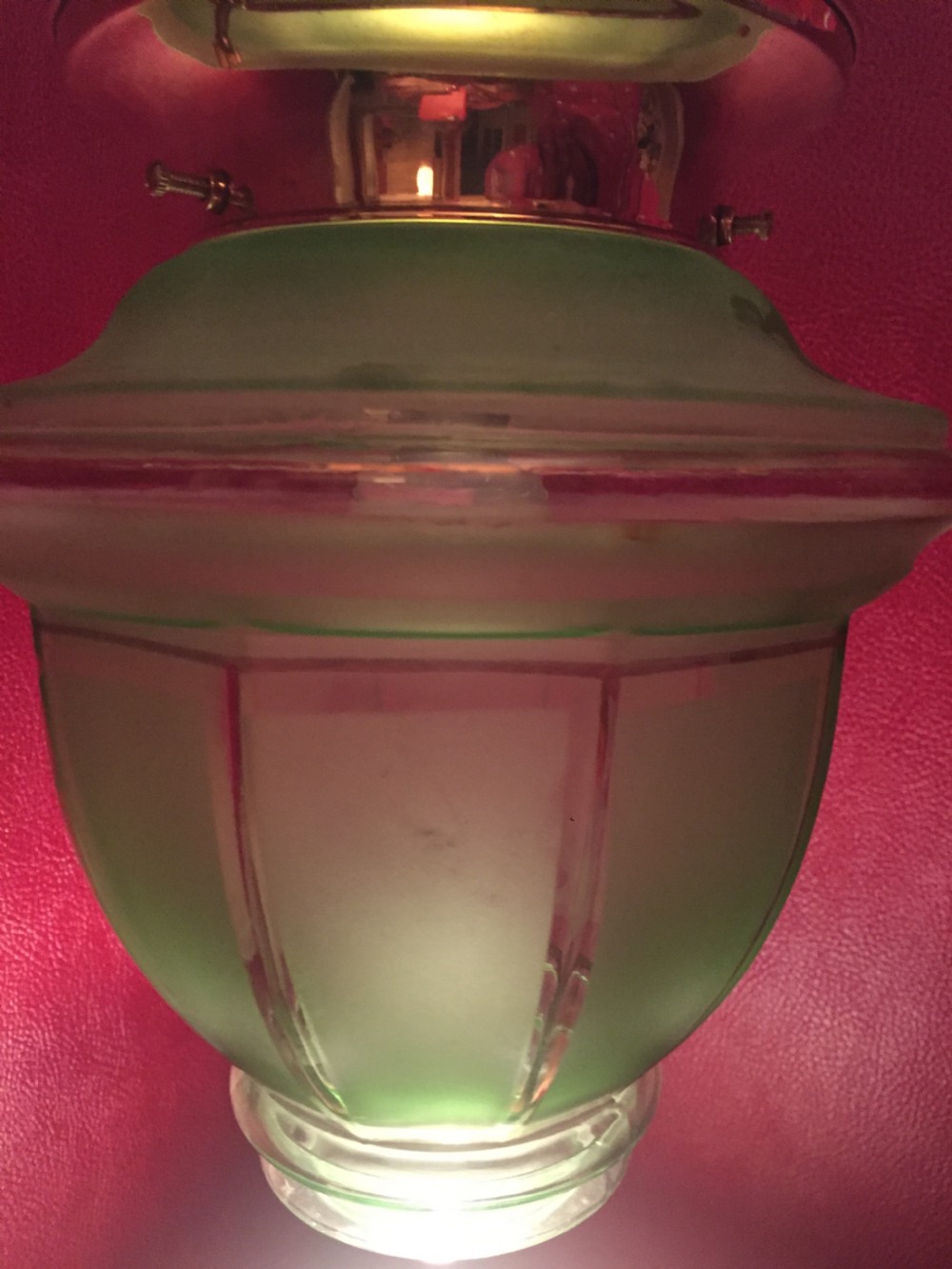 An illuminated Art Deco ceiling globe made of green frosted glass with ribbed panel details. View V