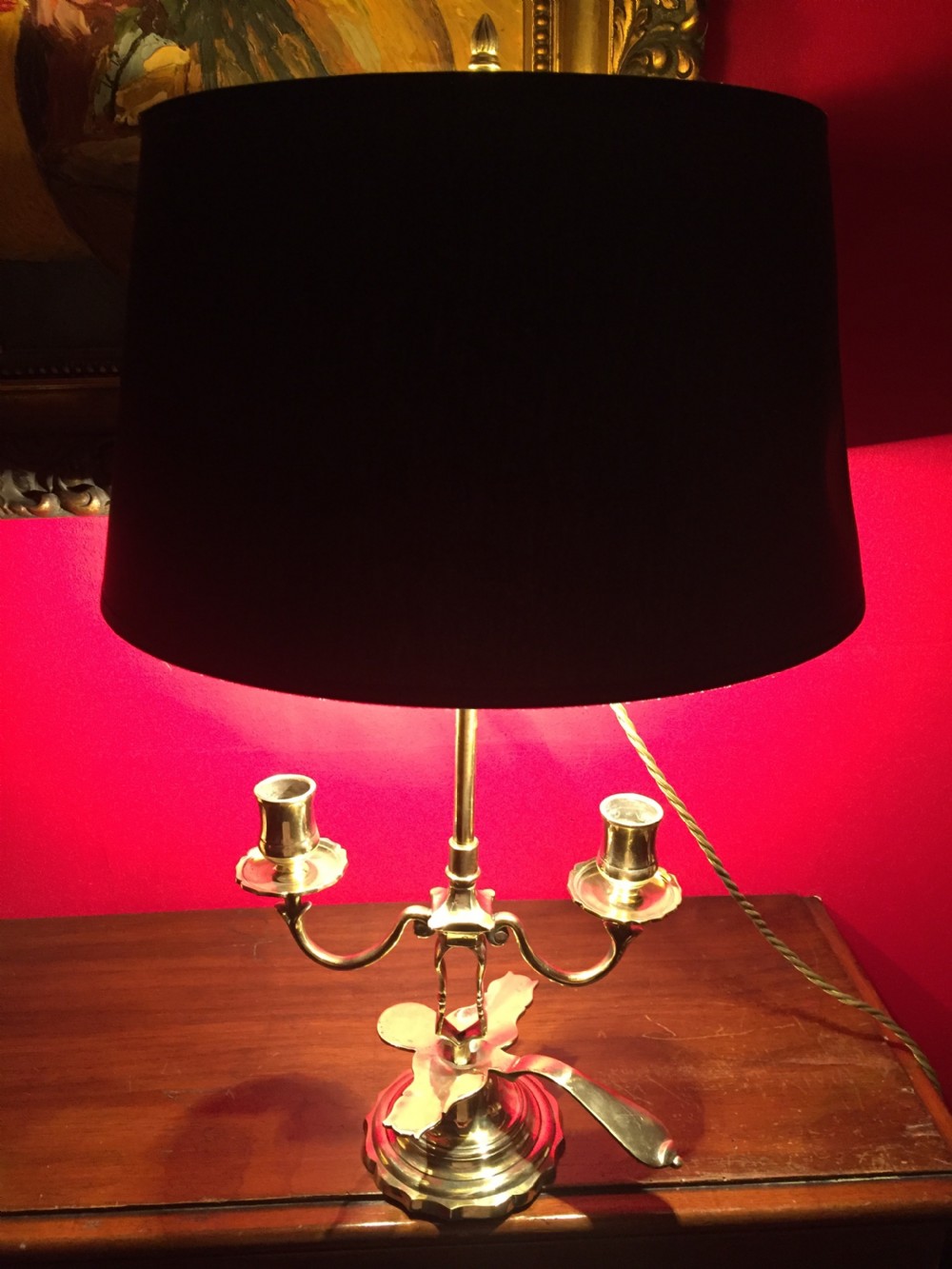 An antique French brass desk lamp with twin candlestick arms and a dark rounded lampshade. View II
