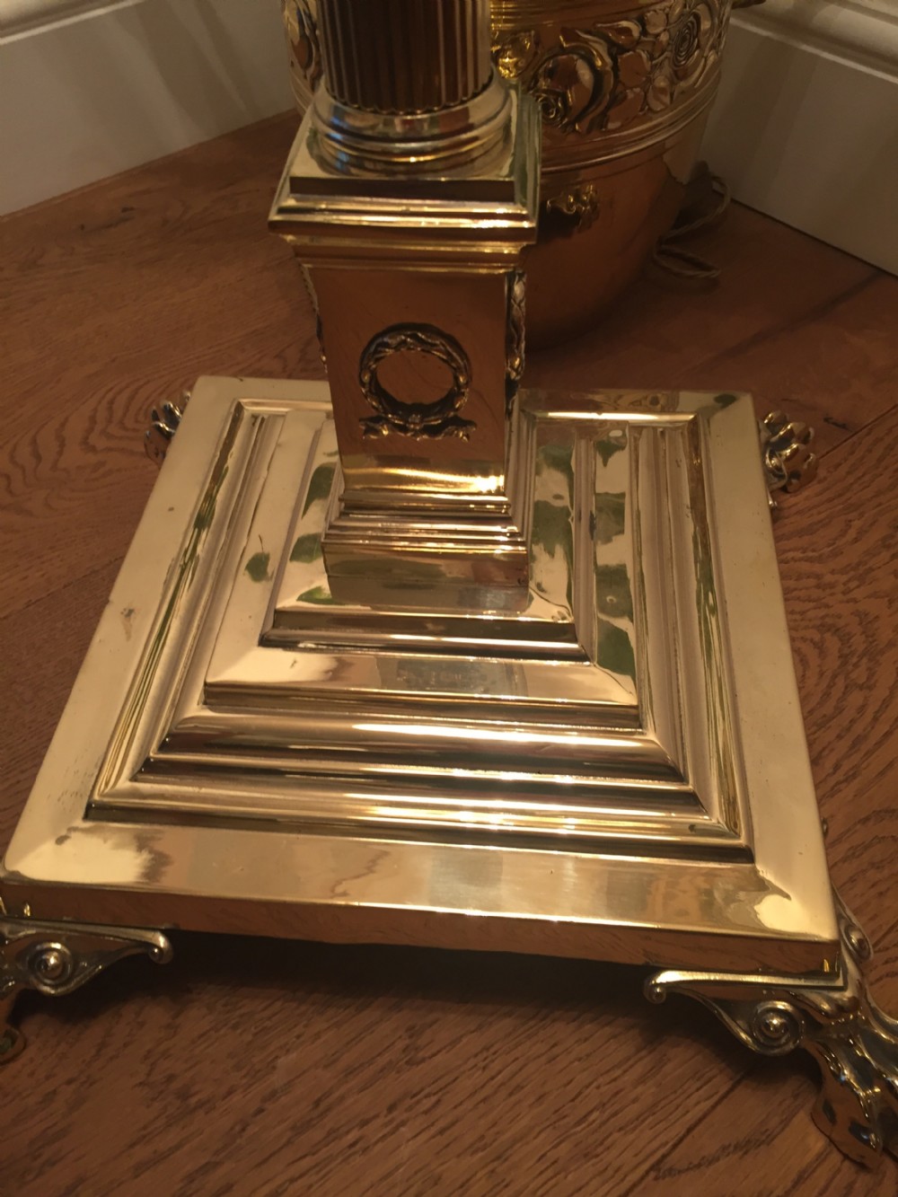 An Edwardian brass telescopic standard lamp featuring a fluted column, Corinthian capital, and a square stepped base with claw feet. View V