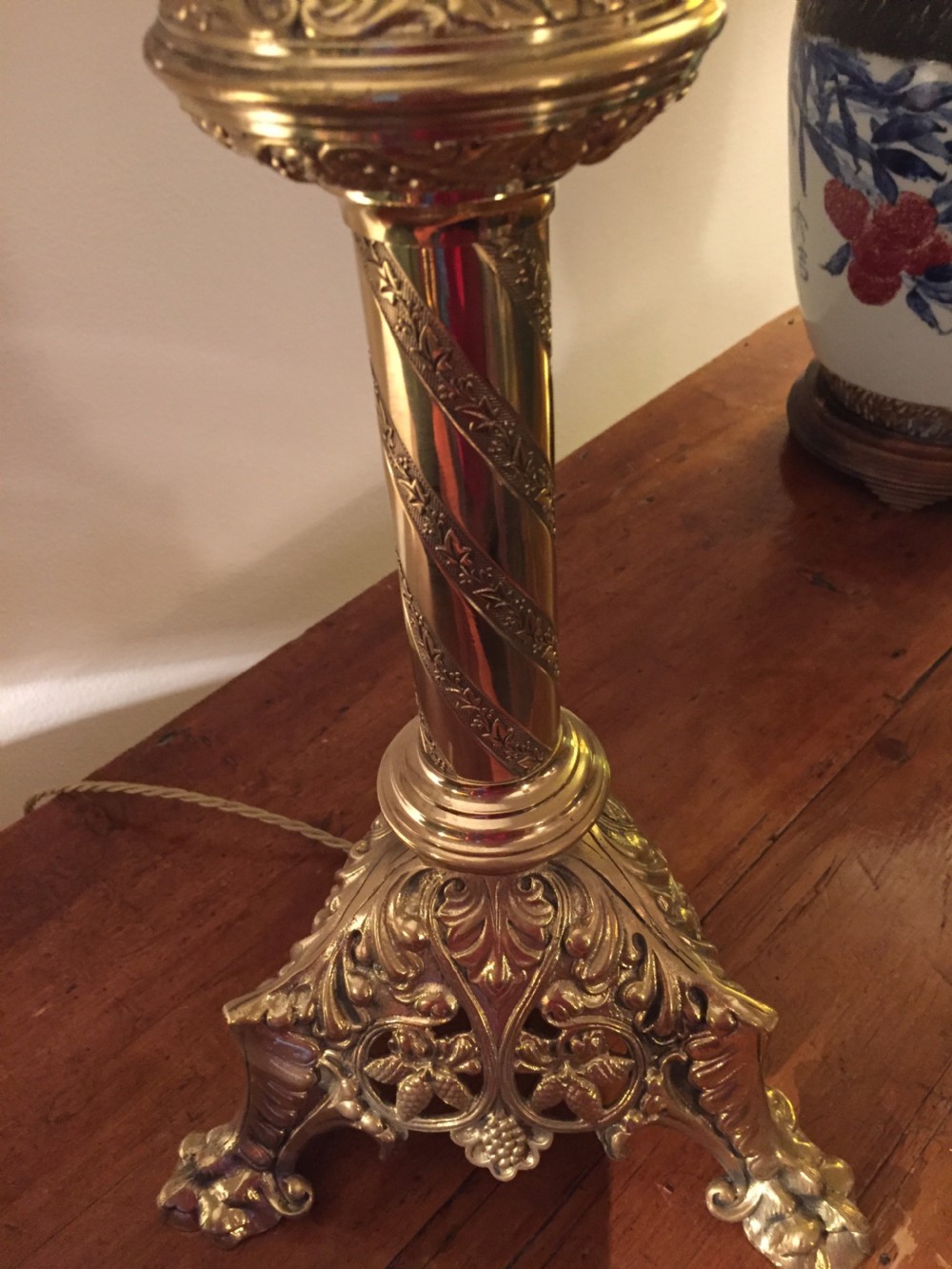 A 19th-century French brass altar candlestick converted into a table lamp, featuring an ornate tri-form base and a spiral-fluted column. View II