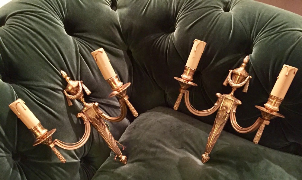 A pair of nineteenth-century French Napoleon III gilt bronze two-arm wall sconces featuring classical urn finials, drapery swags, and acanthus leaf detailing. View II