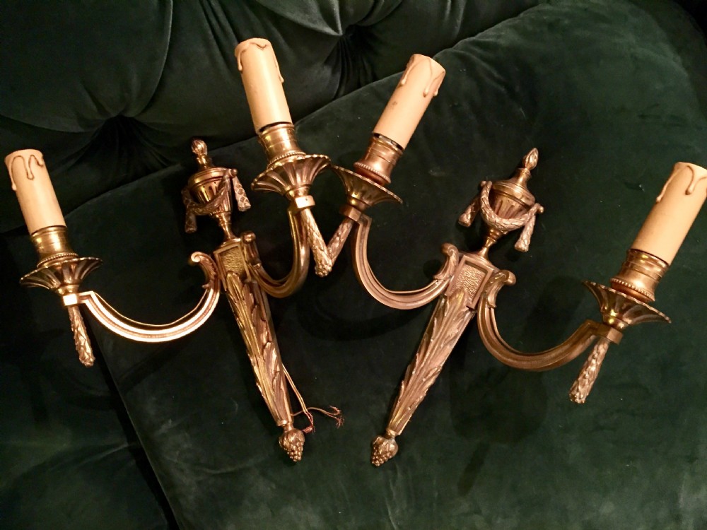 A pair of nineteenth-century French Napoleon III gilt bronze two-arm wall sconces featuring classical urn finials, drapery swags, and acanthus leaf detailing. View VI