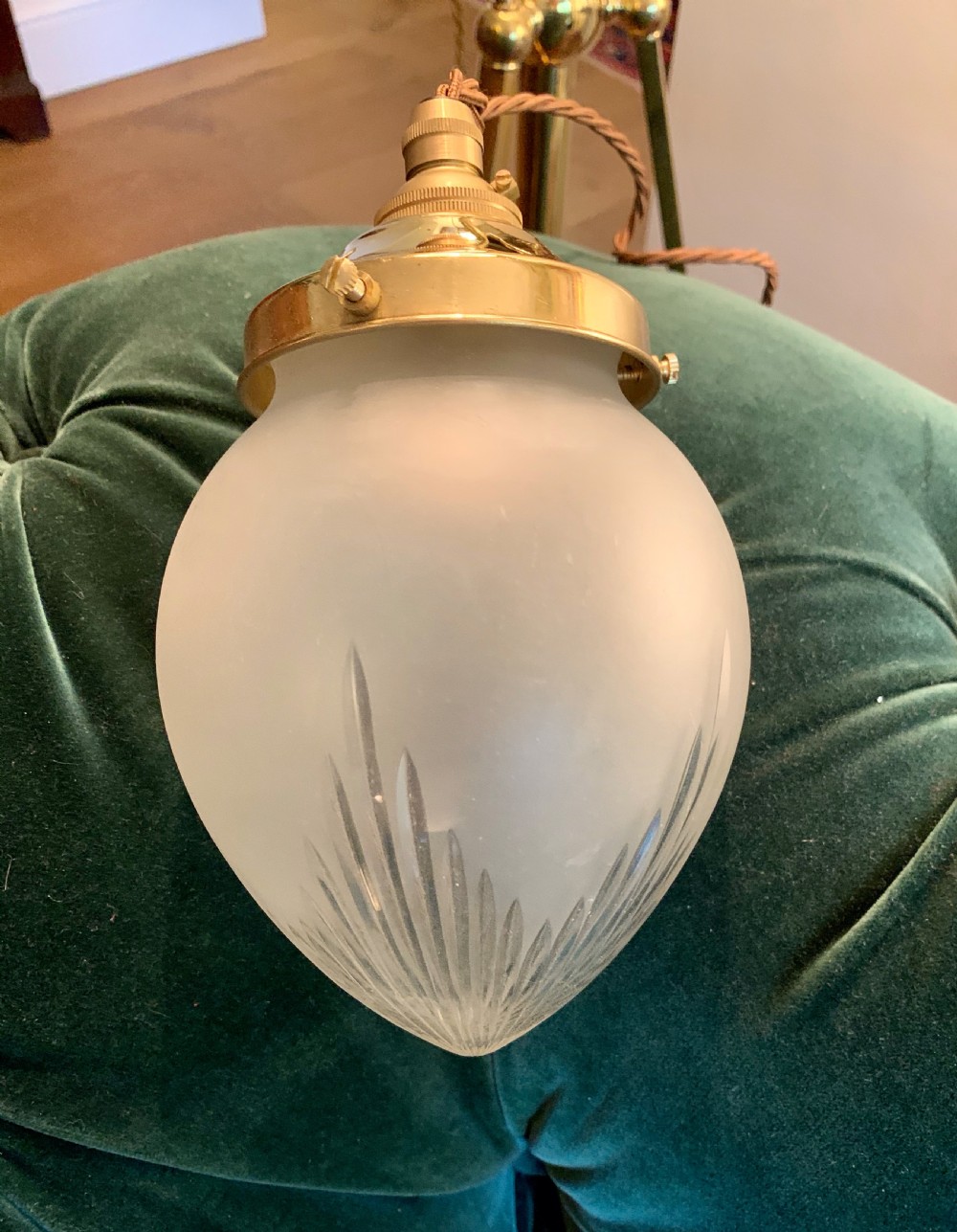 An Edwardian period frosted glass pendant lantern featuring cut leaf details at the base and a polished brass top gallery.