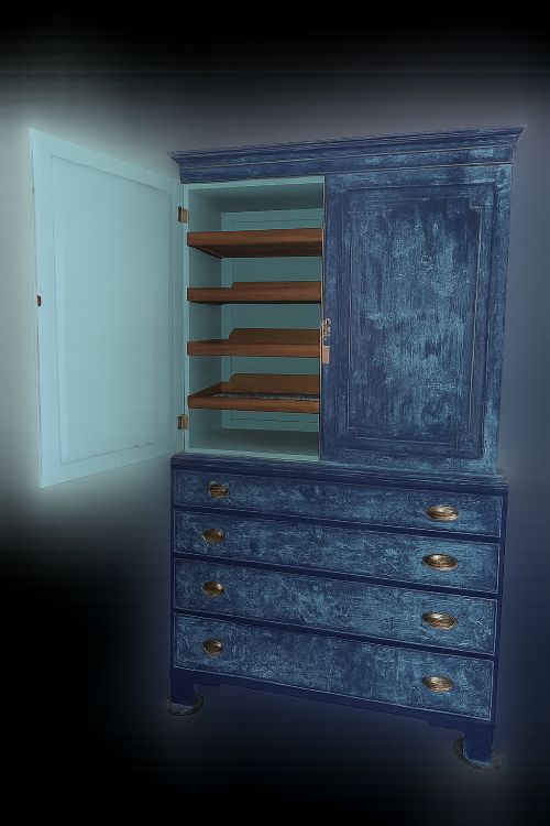 fig 3. A tall 19th-century Regency linen press featuring a distressed blue painted finish, two upper cupboard doors, and four lower drawers with brass handles.