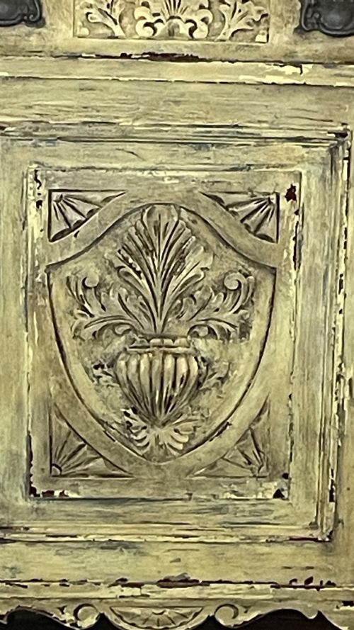fig 3. An antique French provincial sideboard featuring distressed yellow painted wood, two carved panel doors with urn motifs, two upper drawers, and a pink marble top surface.