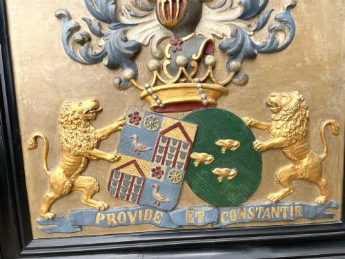 fig 3. A framed 19th-century Dutch heraldic marriage plaque depicting two carved gilt lion supporters holding alliance coats of arms under a helmet crest and motto banner.
