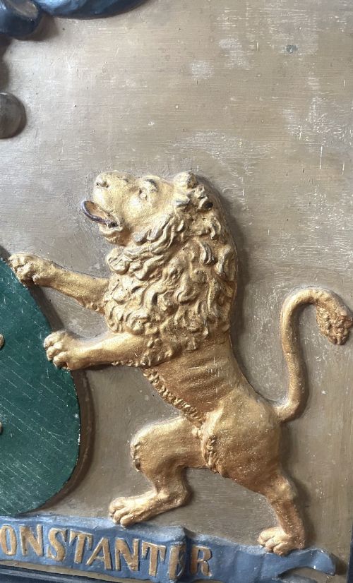 fig 5. A framed 19th-century Dutch heraldic marriage plaque depicting two carved gilt lion supporters holding alliance coats of arms under a helmet crest and motto banner.