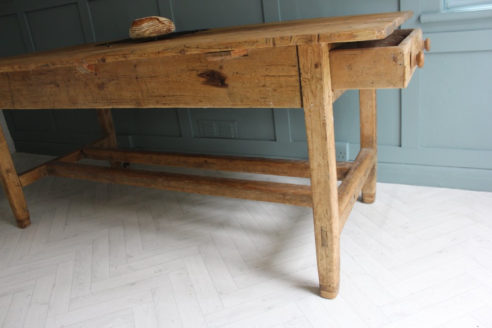 A 19th century rectangular Irish pine farmhouse table featuring square legs, lower H-stretchers, and a warm timber finish. View VI