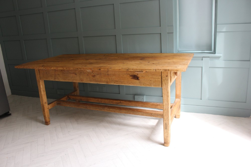 A 19th century rectangular Irish pine farmhouse table featuring square legs, lower H-stretchers, and a warm timber finish. View XII
