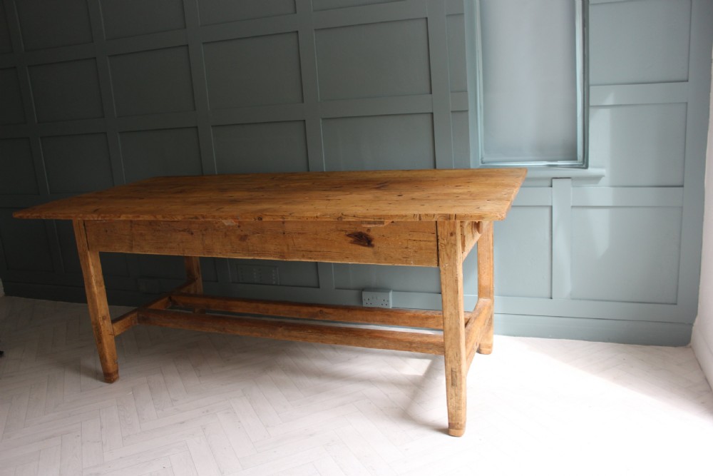 A 19th century rectangular Irish pine farmhouse table featuring square legs, lower H-stretchers, and a warm timber finish. View XIII
