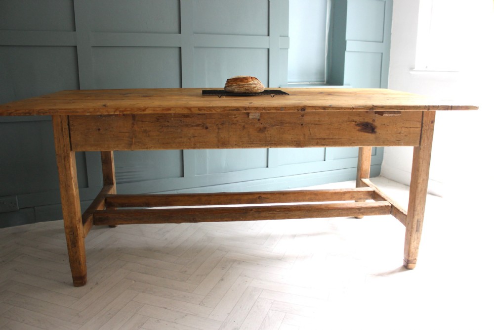 A 19th century rectangular Irish pine farmhouse table featuring square legs, lower H-stretchers, and a warm timber finish. View XV