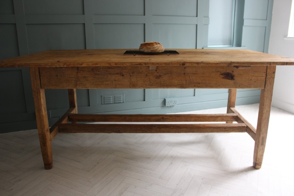 A 19th century rectangular Irish pine farmhouse table featuring square legs, lower H-stretchers, and a warm timber finish. View XVI