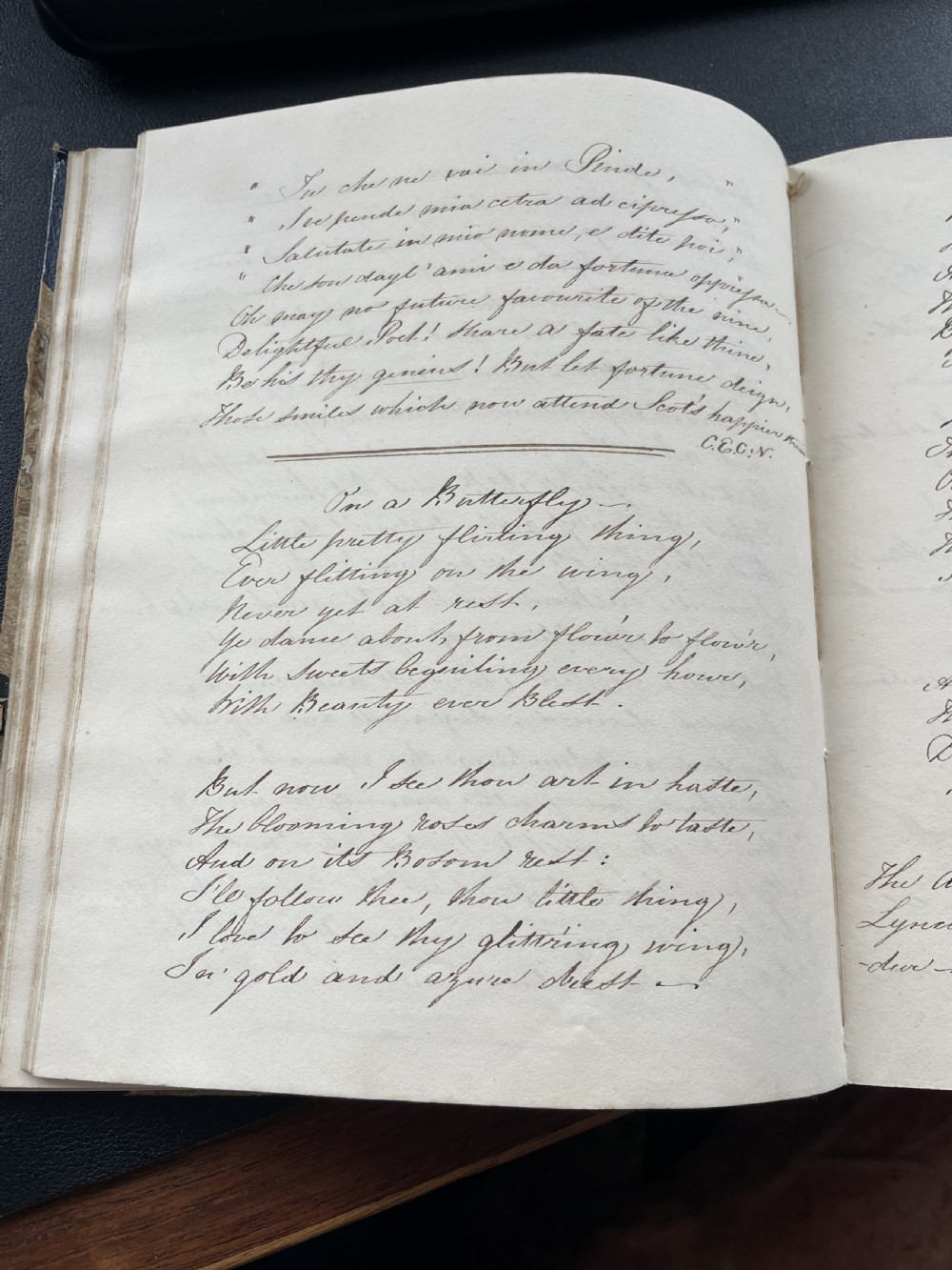 An antique book with dark blue quarter leather binding, gold tooling lines, and brown marbled paper boards. View VII