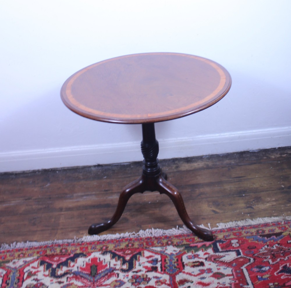 An 18th-century George III mahogany tilt-top tripod table with a circular crossbanded top tilted vertically on a turned stem and splayed legs. View VIII