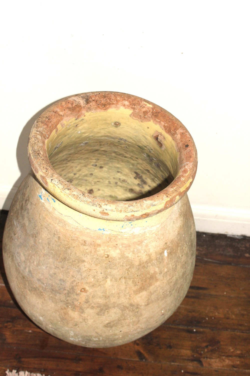 A 19th-century French terracotta Biot jar featuring an unglazed weathered body and a round lip finished with yellow glaze. View V