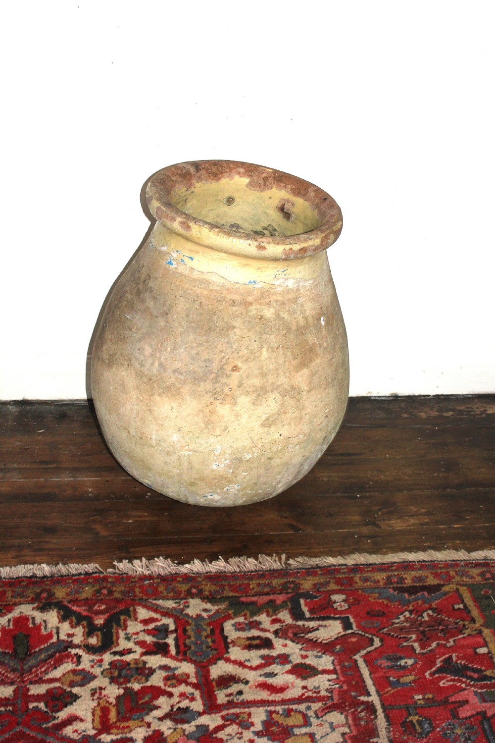 A 19th-century French terracotta Biot jar featuring an unglazed weathered body and a round lip finished with yellow glaze. View VI