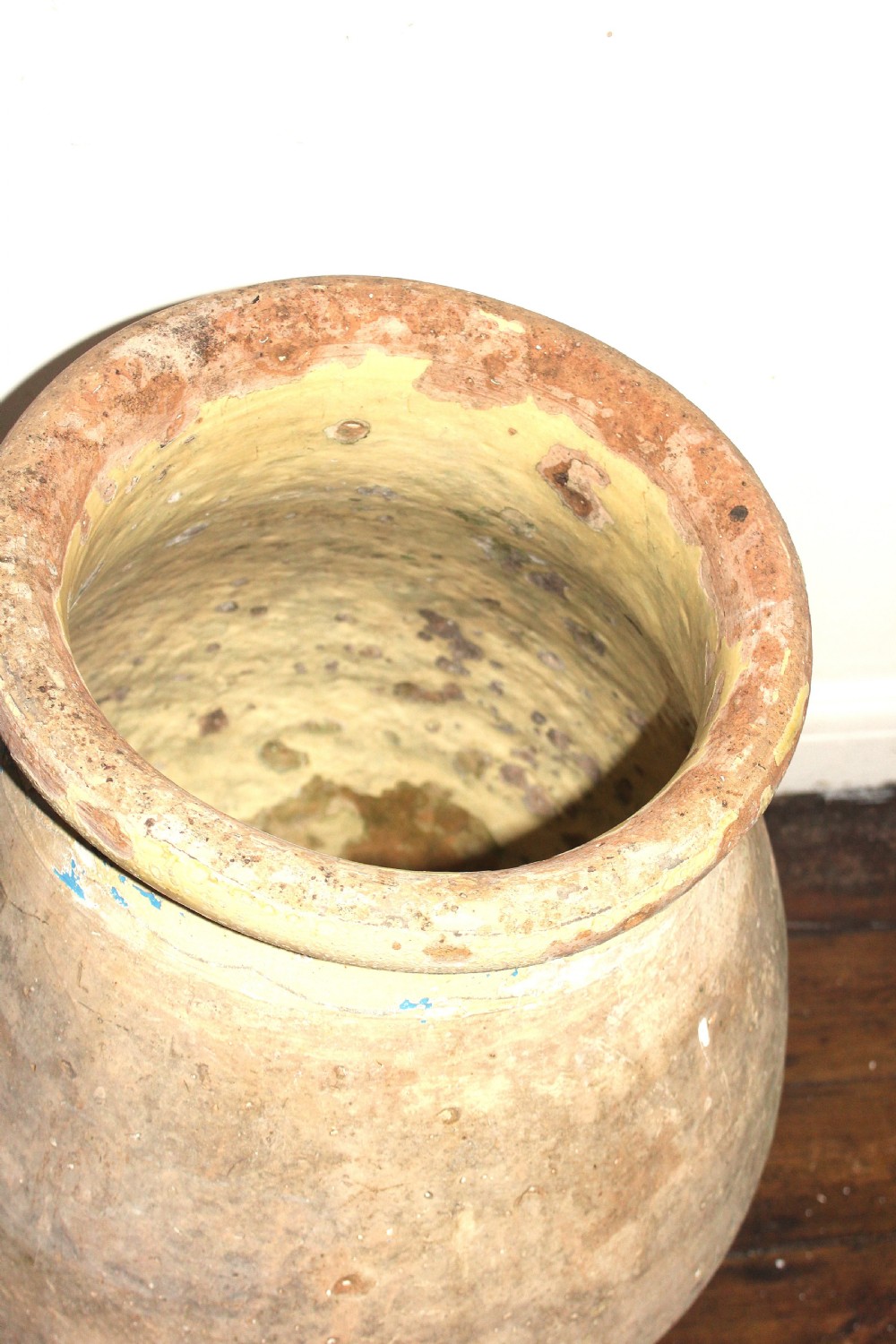 A 19th-century French terracotta Biot jar featuring an unglazed weathered body and a round lip finished with yellow glaze. View VII
