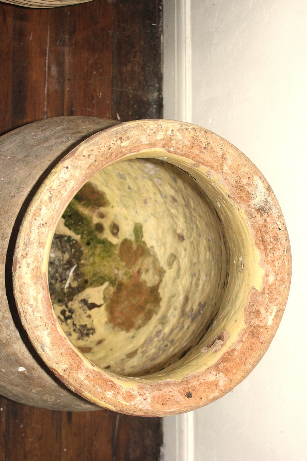 A 19th-century French terracotta Biot jar featuring an unglazed weathered body and a round lip finished with yellow glaze. View X