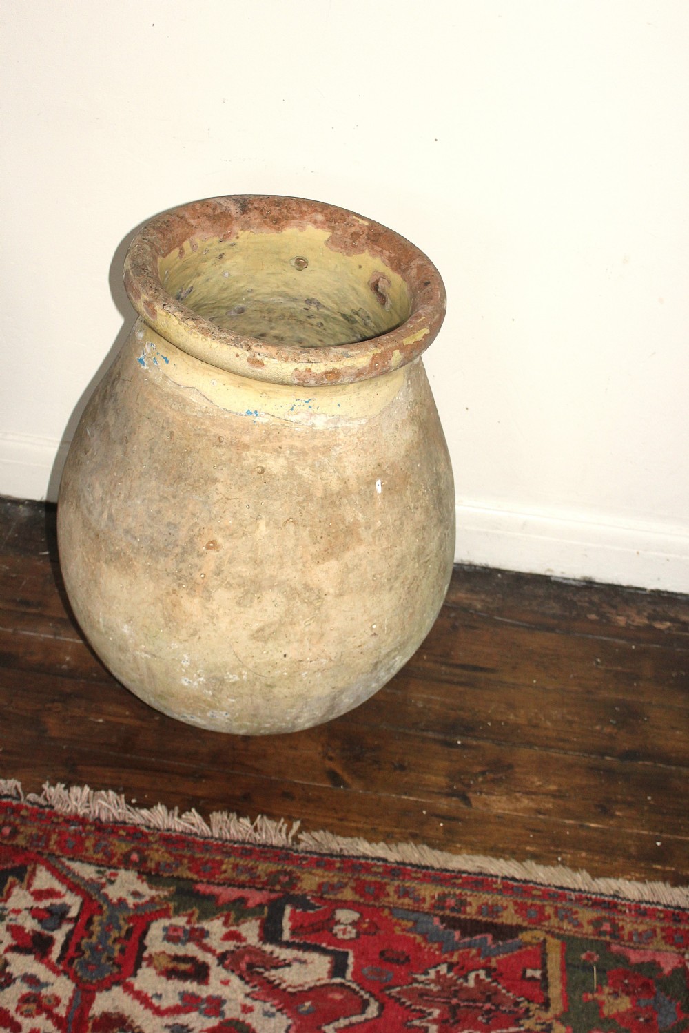 A 19th-century French terracotta Biot jar featuring an unglazed weathered body and a round lip finished with yellow glaze. View XII