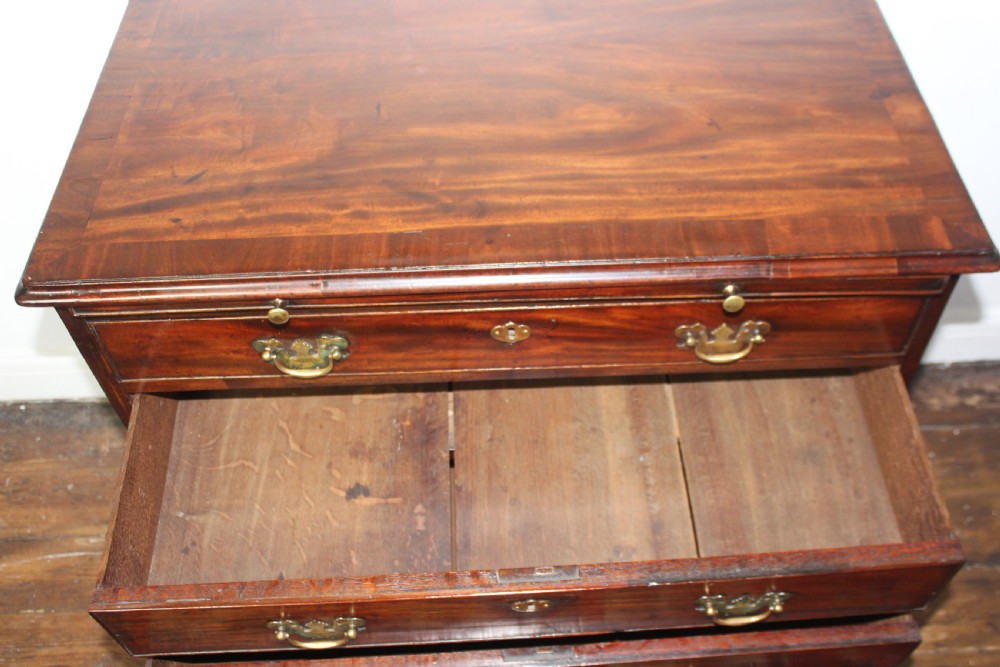 A George II mahogany chest of drawers featuring four graduated drawers with brass handles and supported on ogee bracket feet. View VIII