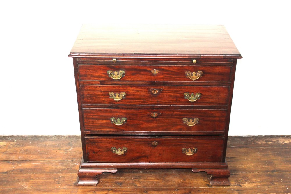 A George II mahogany chest of drawers featuring four graduated drawers with brass handles and supported on ogee bracket feet. View IX