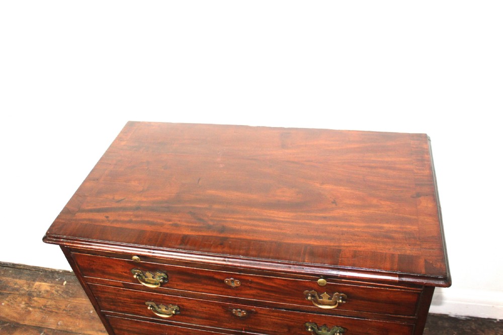 A George II mahogany chest of drawers featuring four graduated drawers with brass handles and supported on ogee bracket feet. View XIII