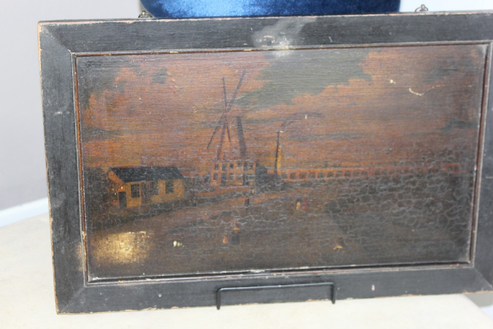 An 18th-century naive topographical oil painting of Staplecross in Sussex depicting village roads, buildings, and a windmill in a dark wooden frame. View VII