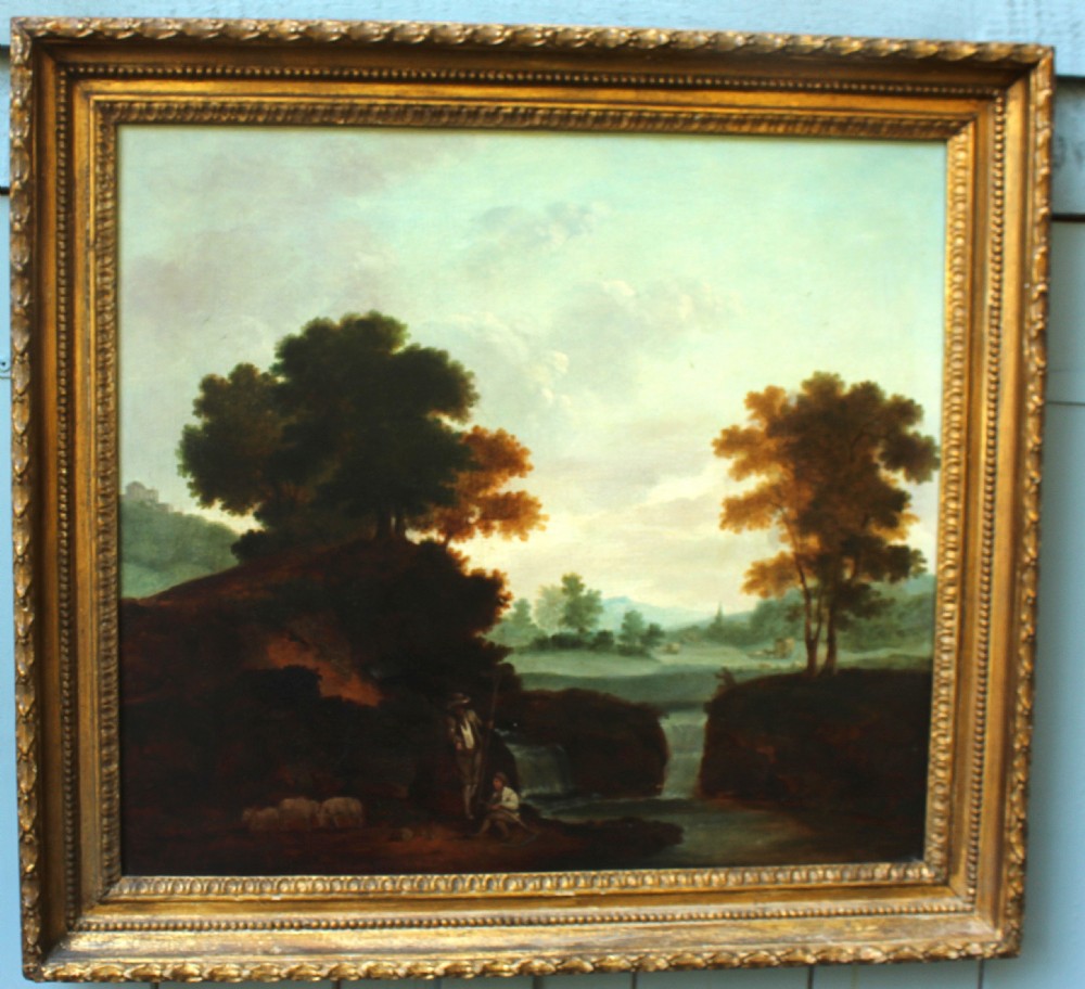 An 18th-century style oil painting on canvas depicting an Italianate landscape with trees, a river, and pastoral figures, set within a molded giltwood frame.