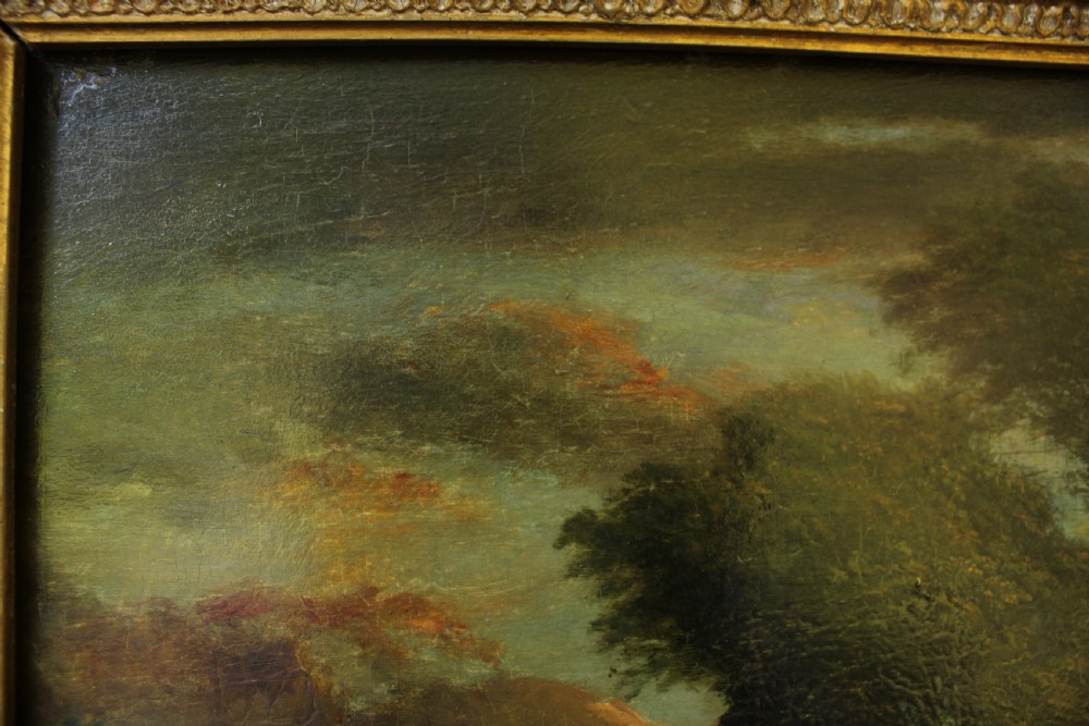 A 19th-century English pastoral oil painting depicting trees, hills, and figures beside a body of water in a moulded gilt frame. View VI