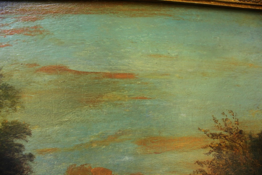 A 19th-century English pastoral oil painting depicting trees, hills, and figures beside a body of water in a moulded gilt frame. View VII