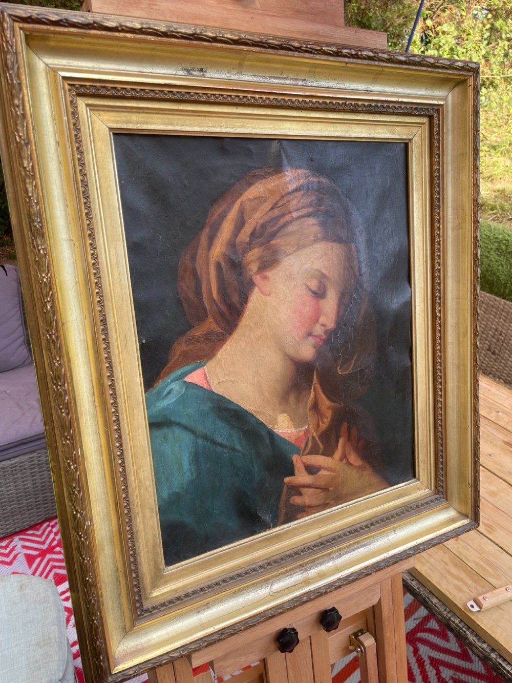An 18th-century oil painting depicting the Virgin Mary with downcast eyes and folded hands, set within a moulded gilt wood frame. View XI