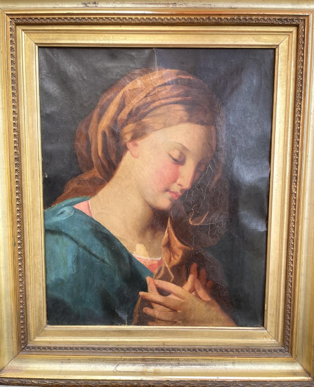 An 18th-century oil painting depicting the Virgin Mary with downcast eyes and folded hands, set within a moulded gilt wood frame.