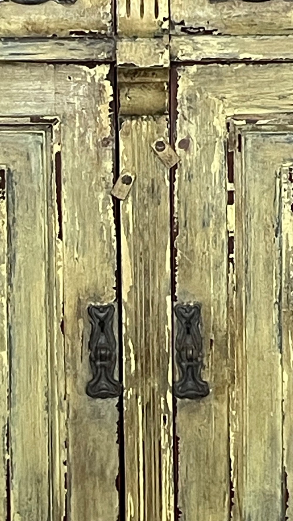 An antique French provincial sideboard featuring distressed yellow painted wood, two carved panel doors with urn motifs, two upper drawers, and a pink marble top surface. View IX