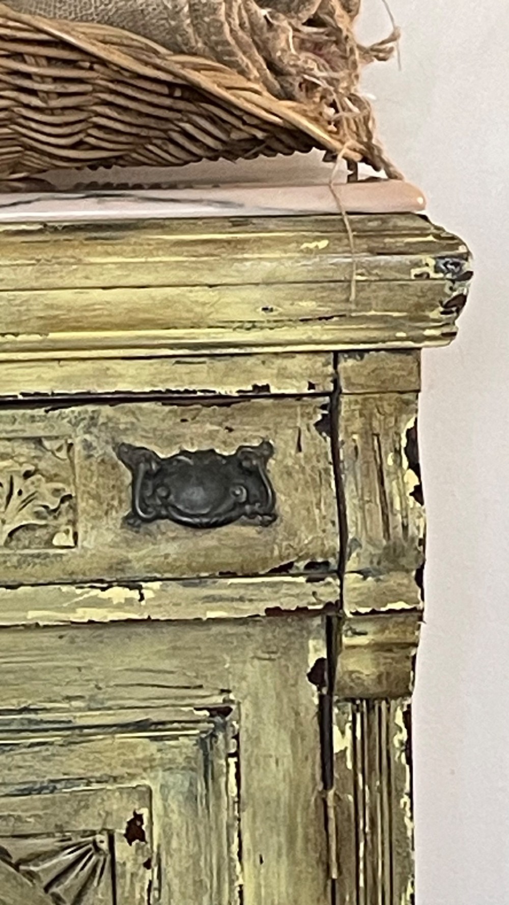 An antique French provincial sideboard featuring distressed yellow painted wood, two carved panel doors with urn motifs, two upper drawers, and a pink marble top surface. View X