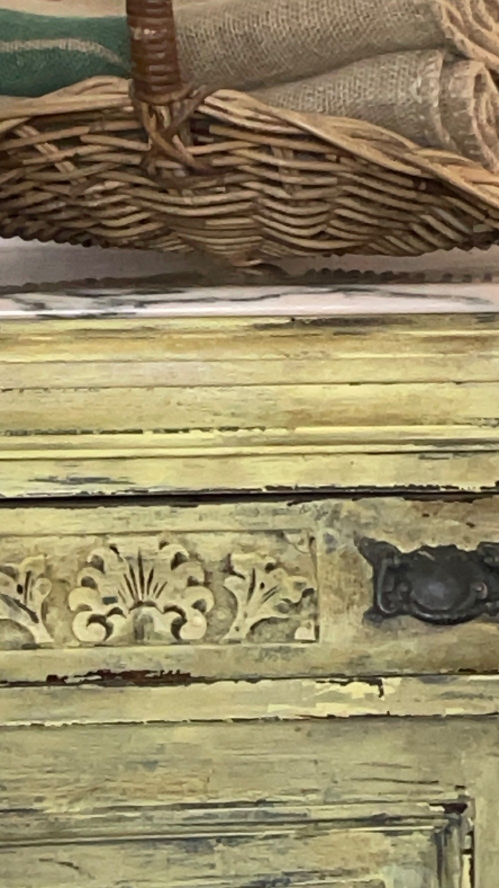 An antique French provincial sideboard featuring distressed yellow painted wood, two carved panel doors with urn motifs, two upper drawers, and a pink marble top surface. View XII