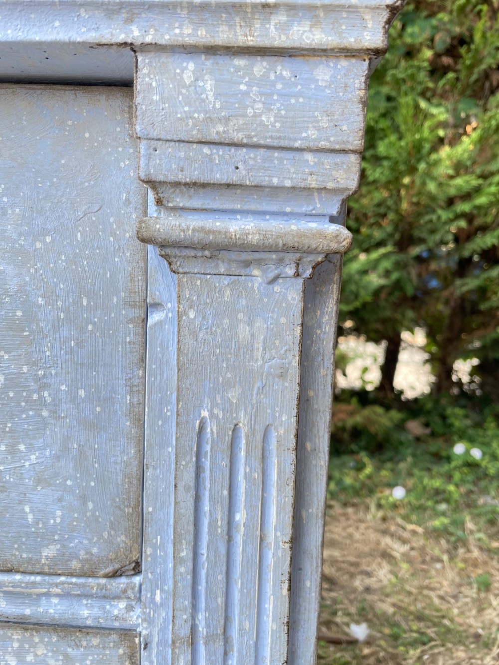 A French Gustavian style chest of drawers featuring a natural wood top, pale blue distressed paint finish, fluted corner pilasters, carved diamond-point details, and metal drop handles. View IV